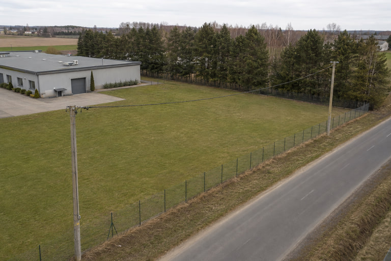 Zabudowa, drzewa, droga i przewody energetyczne ograniczające geometrię bezpiecznego lotu - wizualizacja poglądowa